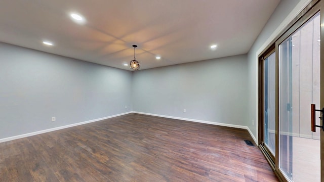 spare room with dark wood-type flooring, recessed lighting, visible vents, and baseboards