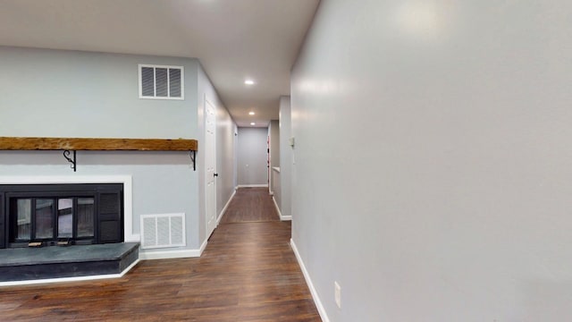 hallway with recessed lighting, wood finished floors, visible vents, and baseboards