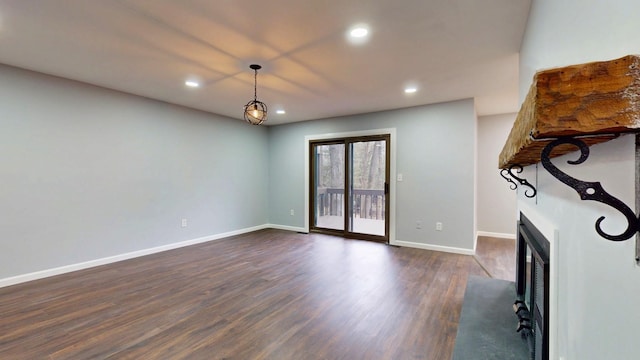 unfurnished living room with dark wood-style floors, recessed lighting, a fireplace, and baseboards