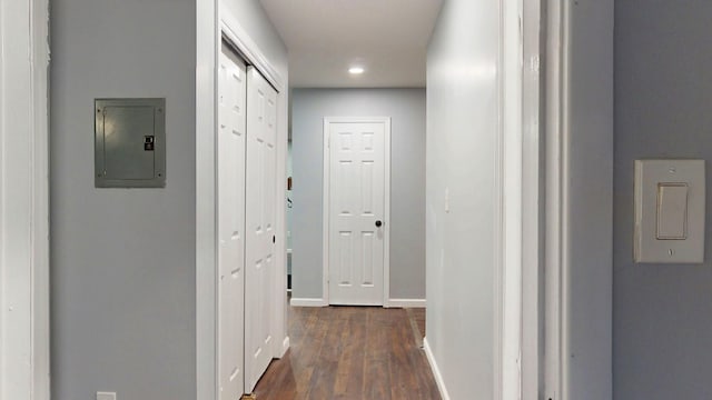 corridor with dark wood-style floors, electric panel, and baseboards