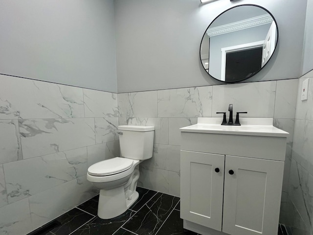 bathroom featuring toilet, marble finish floor, and vanity