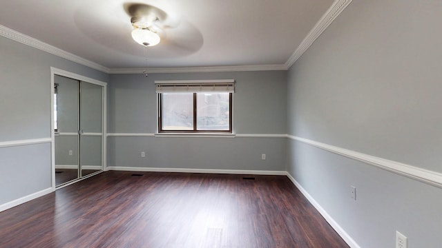 unfurnished bedroom featuring ornamental molding, a closet, baseboards, and wood finished floors