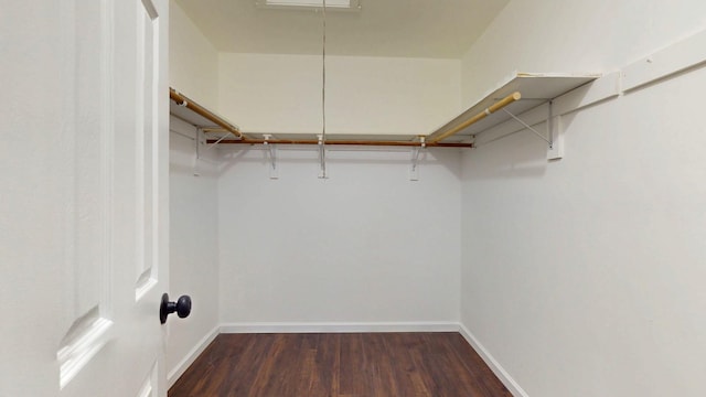 walk in closet with attic access and wood finished floors