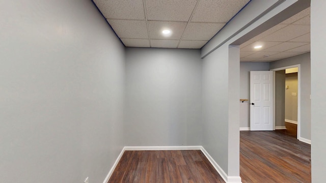 hallway with baseboards, a drop ceiling, wood finished floors, and recessed lighting