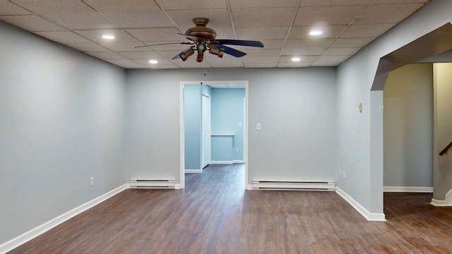 spare room with baseboards, a baseboard heating unit, and wood finished floors