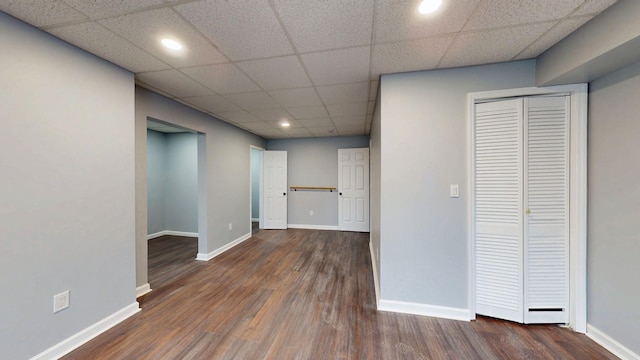 basement featuring a paneled ceiling, recessed lighting, baseboards, and wood finished floors