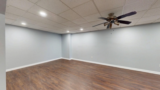 unfurnished room featuring a paneled ceiling, dark wood-style flooring, ceiling fan, and baseboards