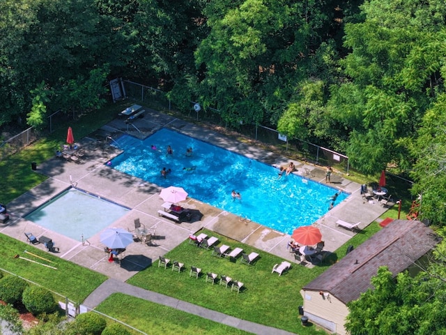 pool with a patio area and fence