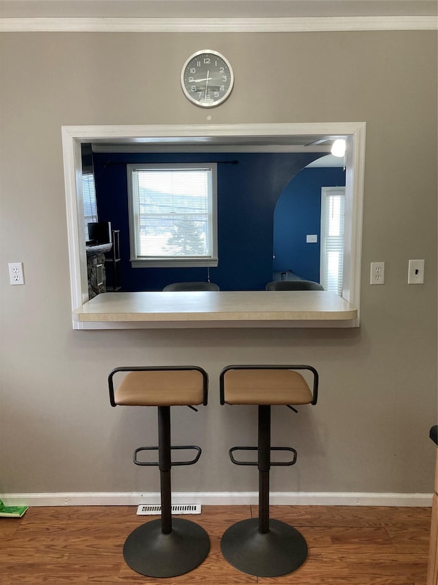 interior space featuring crown molding, baseboards, and wood finished floors