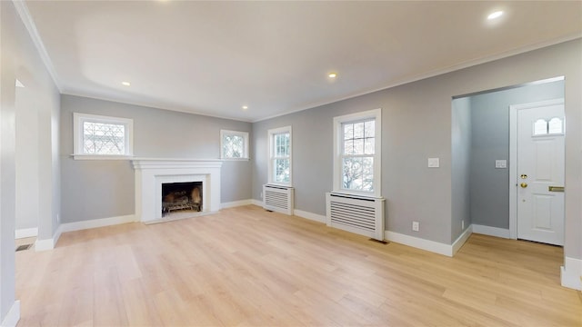 unfurnished living room featuring baseboards, a fireplace with flush hearth, crown molding, light wood-style floors, and recessed lighting