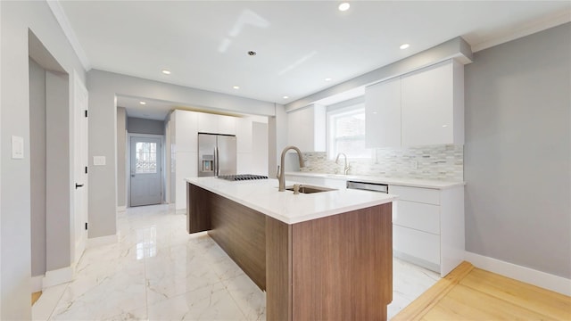 kitchen with tasteful backsplash, stainless steel fridge with ice dispenser, modern cabinets, white cabinetry, and a sink