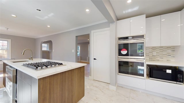 kitchen with wine cooler, modern cabinets, marble finish floor, stainless steel appliances, and a sink