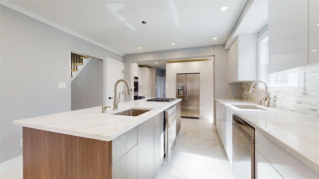 kitchen with marble finish floor, appliances with stainless steel finishes, modern cabinets, and a sink