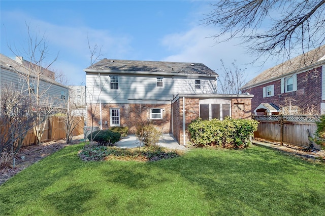 back of property featuring a patio area, brick siding, a yard, and a fenced backyard