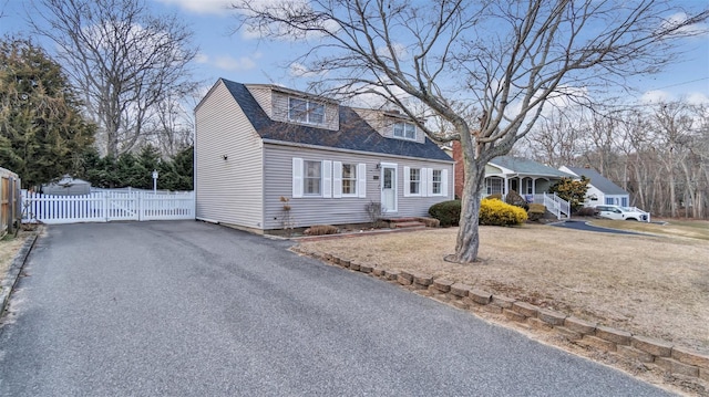 5225 Peconic Bay Blvd, Laurel, NY 11948 - cape cod-style house with aphalt driveway, roof with shingles, and fence