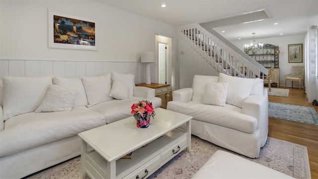 living room with an inviting chandelier, stairs, light wood-style floors, and recessed lighting