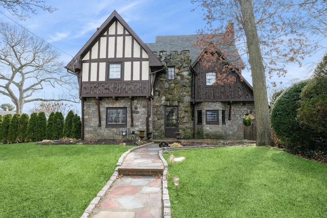 tudor-style house with stone siding and a front lawn