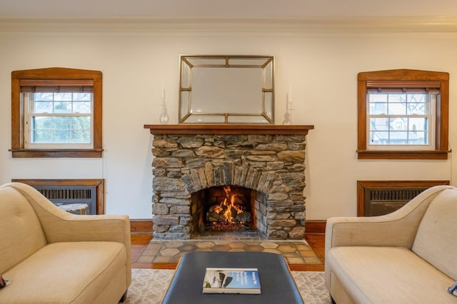 sitting room with crown molding and a stone fireplace