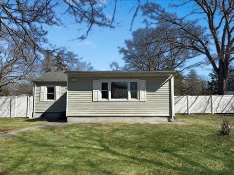 exterior space featuring fence and a lawn