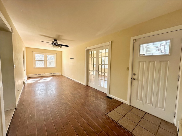 entryway featuring french doors, dark wood finished floors, visible vents, baseboard heating, and baseboards