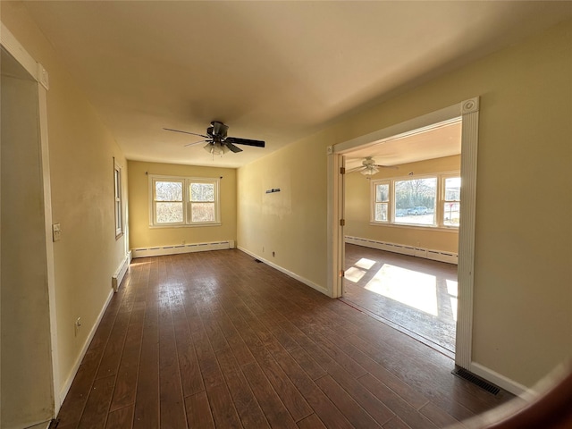 spare room featuring a wealth of natural light, a baseboard radiator, and dark wood-style flooring