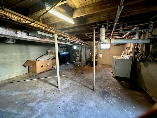 below grade area featuring washer and clothes dryer, heating unit, and heating fuel