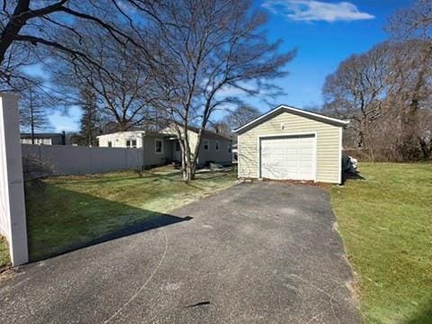 detached garage with fence and aphalt driveway