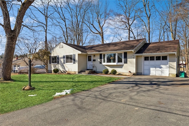 ranch-style house featuring a garage, a front yard, entry steps, and aphalt driveway