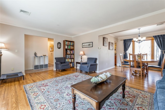 living room with crown molding, visible vents, and wood finished floors