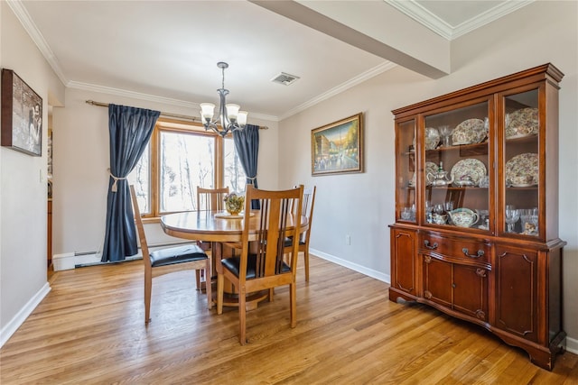 dining room with crown molding, visible vents, light wood-style flooring, a chandelier, and baseboards