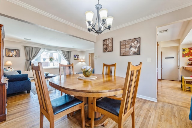 dining room featuring light wood-style floors, visible vents, and crown molding