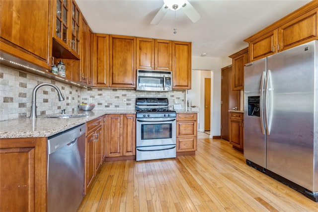 kitchen featuring brown cabinets, stainless steel appliances, and a sink