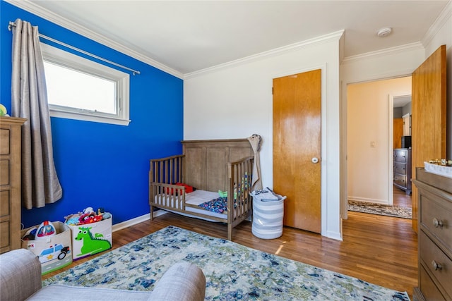 bedroom with baseboards, wood finished floors, and crown molding