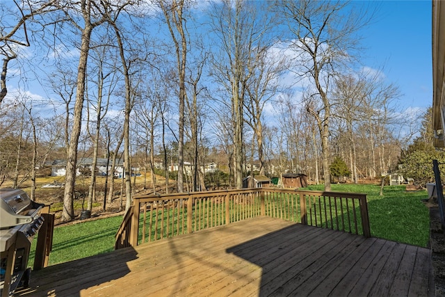 wooden deck with a yard, a storage unit, grilling area, and an outbuilding