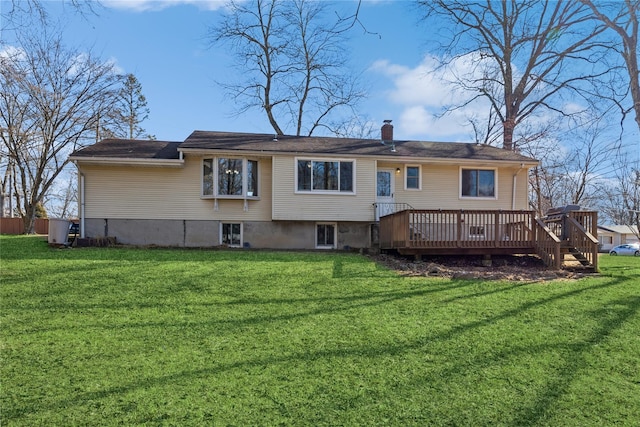 back of house with a deck, a chimney, and a lawn