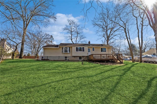 rear view of house featuring a chimney, fence, a lawn, and a wooden deck