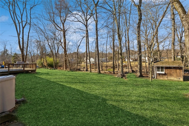 view of yard with an outbuilding, a deck, and a shed