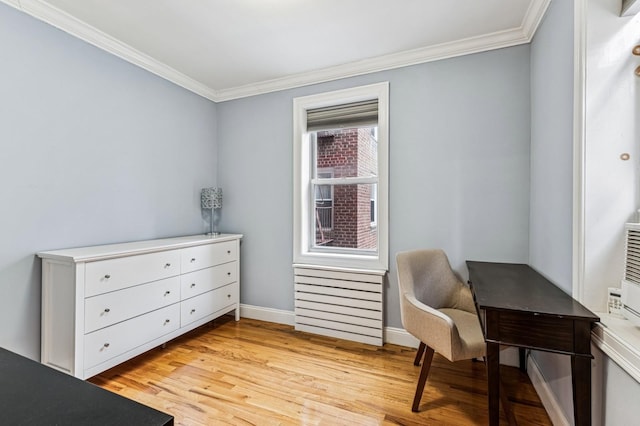 living area featuring light wood finished floors, baseboards, and crown molding