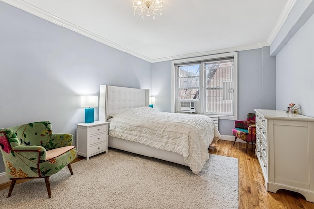 bedroom with cooling unit, crown molding, an inviting chandelier, light wood-type flooring, and baseboards