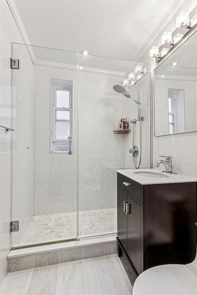 bathroom with ornamental molding, a shower stall, and vanity