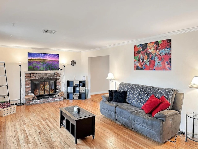 living room featuring ornamental molding, a glass covered fireplace, and wood finished floors