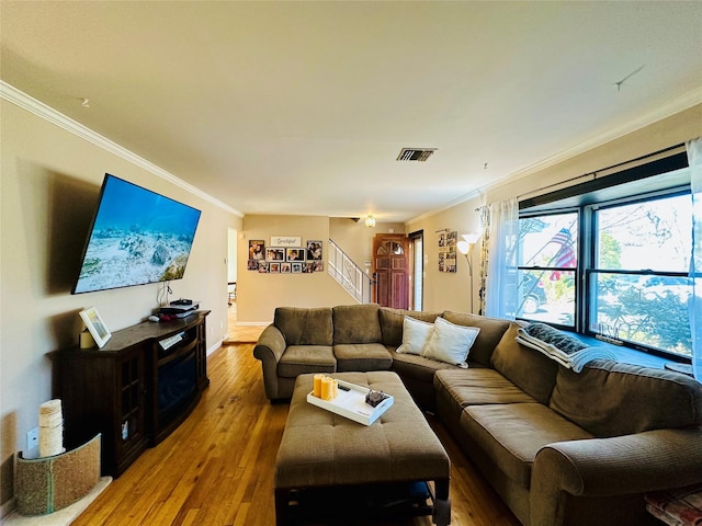 living room featuring visible vents, baseboards, stairway, ornamental molding, and hardwood / wood-style flooring