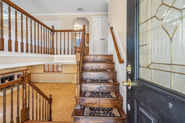 stairs with baseboard heating, carpet flooring, visible vents, and crown molding