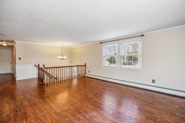 spare room with a baseboard radiator, crown molding, a chandelier, and wood finished floors