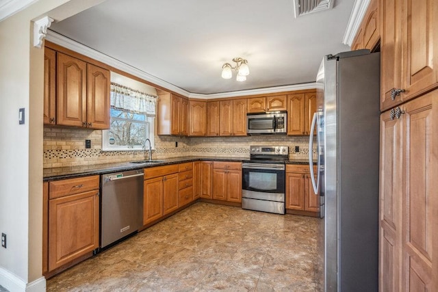 kitchen featuring stainless steel appliances, dark countertops, visible vents, brown cabinetry, and a sink