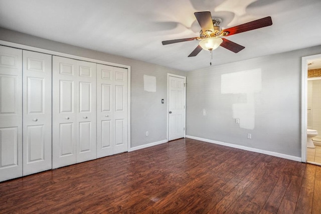 unfurnished bedroom featuring ensuite bath, baseboards, and wood finished floors