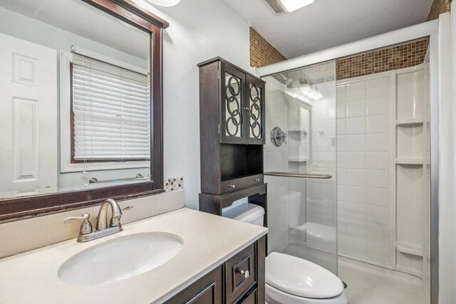 bathroom featuring a stall shower, vanity, and toilet