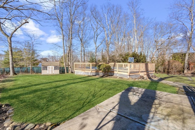 view of yard with a storage shed, an outdoor structure, a wooden deck, and fence