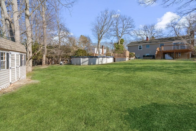 view of yard featuring a wooden deck and a covered pool