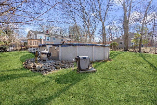 back of house with a covered pool, a chimney, a lawn, and a wooden deck